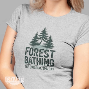 May include: A gray t-shirt with a green forest scene and the text "Forest Bathing The Original Spa Day".