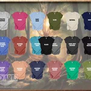 Op de afbeelding: Een display van 18 verschillende gekleurde T-shirts met verschillende heather en effen kleuren. De T-shirts hebben verschillende tekst erop gedrukt, waaronder "Athletic Heather", "Berry", "Baby Blue", "Olive", "Natural", "Navy", "Heather Columbia Blue", "Heather Clay", "Heather Aqua", "Deep Heather", "Dark Grey Heather", "Black Heather", "Heather Team Purple", "Heather Peach", "Heather Navy", "Heather Mauve", "Heather Kelly", en "Heather Green".