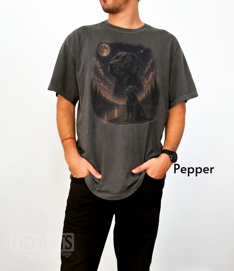 Puede incluir: Camiseta gris oscuro con un gr&aacute;fico de un Labrador Retriever negro bajo la luna llena. El dise&ntilde;o incluye una escena de bosque y lago. La palabra "Pepper" est&aacute; impresa en el lado derecho de la imagen.