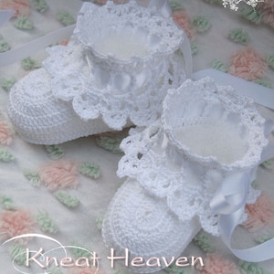 May include: White crocheted baby booties with satin ribbon ties. The booties have a delicate lace trim and are perfect for a special occasion.