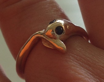 May include: Gold ring with a black gemstone in the shape of a snake's head.