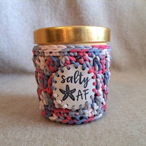 May include: A crocheted jar cozy in pink, gray, and white with a white circle label that says "salty AF" with a starfish graphic.