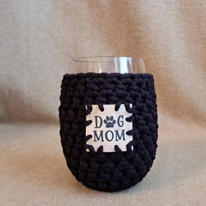 May include: Black crocheted wine glass cozy with a white square patch that says "Dog Mom" with a paw print.