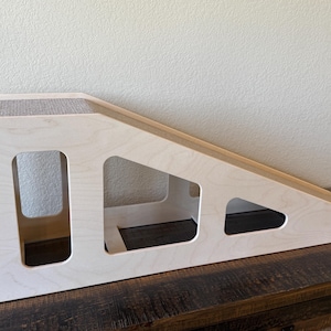 May include: A white wooden cat ramp with three openings. The ramp is covered in sisal rope and is angled upwards.