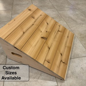 May include: A wooden ramp with a natural wood finish. The ramp is angled and has a smooth surface. The text "Custom Sizes Available" is printed on a white rectangle below the ramp.