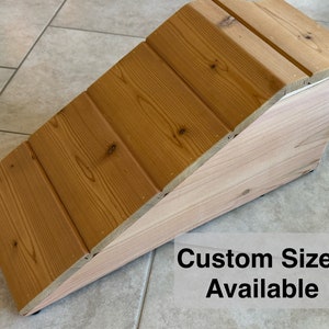 May include: A wooden ramp with a natural wood finish. The ramp is made of multiple planks of wood and has a slight angle. The text "Custom Sizes Available" is printed on the bottom right corner of the image.