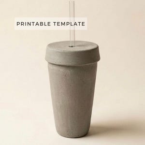 May include: A gray concrete tumbler with a matching lid and a clear glass straw. The tumbler has a cylindrical shape and the text "PRINTABLE TEMPLATE" is displayed on a white rectangle above the tumbler.