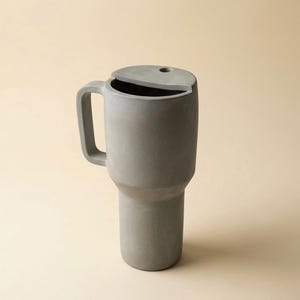 以下が含まれることがあります： 斑点のあるマット仕上げのセラミックマグカップ3個セット。マグカップはクリーム、ライトグレー、ダークグレーの色合いです。各マグカップはシンプルでミニマリストなデザインです。