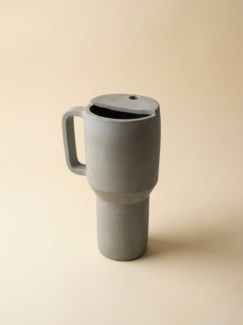 以下が含まれることがあります： 斑点のあるマット仕上げのセラミックマグカップ3個セット。マグカップはクリーム、ライトグレー、ダークグレーの色合いです。各マグカップはシンプルでミニマリストなデザインです。