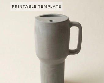 Puede incluir: Un vaso cilíndrico gris con asa y un pequeño agujero en la parte superior. Las palabras "PRINTABLE TEMPLATE" están impresas en un rectángulo blanco encima del vaso. El vaso está hecho de un material sólido y liso.