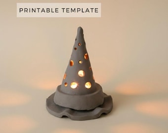 May include: A gray ceramic cone-shaped luminary with a wide, wavy brim and circular cutouts of varying sizes. Warm light glows from within the structure, casting soft light onto the surface. The text PRINTABLE TEMPLATE appears above.