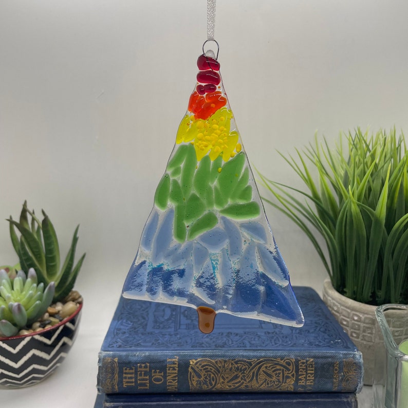 Add a touch of elegance and charm to your holiday decor with our handcrafted fused glass Christmas trees. Each ornament showcases vibrant colors and unique designs that will make your tree truly stand out.