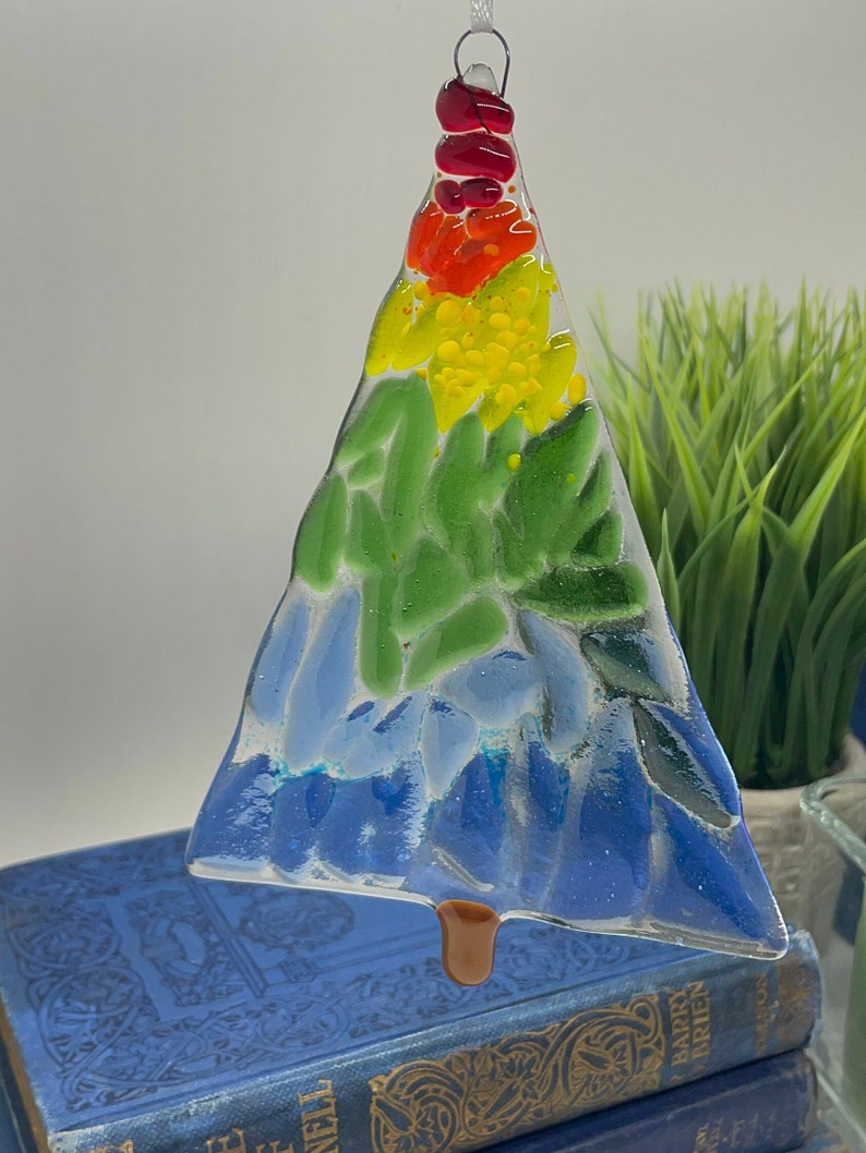 Add a touch of elegance and charm to your holiday decor with our handcrafted fused glass Christmas trees. Each ornament showcases vibrant colors and unique designs that will make your tree truly stand out.