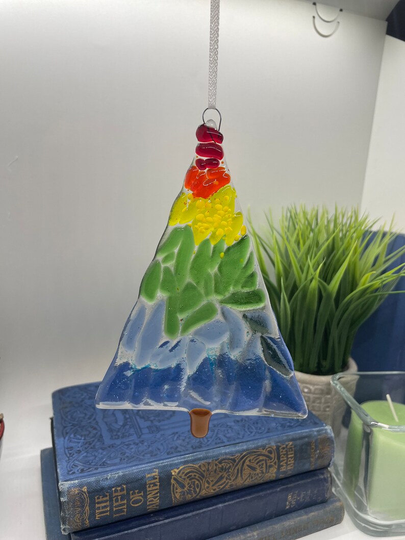 Add a touch of elegance and charm to your holiday decor with our handcrafted fused glass Christmas trees. Each ornament showcases vibrant colors and unique designs that will make your tree truly stand out.