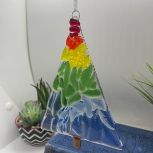 Add a touch of elegance and charm to your holiday decor with our handcrafted fused glass Christmas trees. Each ornament showcases vibrant colors and unique designs that will make your tree truly stand out.