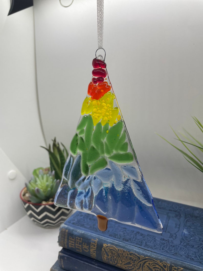 Add a touch of elegance and charm to your holiday decor with our handcrafted fused glass Christmas trees. Each ornament showcases vibrant colors and unique designs that will make your tree truly stand out.