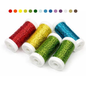 May include: Six spools of colorful metallic thread in red, yellow, green, teal, and two shades of green. The spools have white plastic sides. A color palette of dots is above the spools.