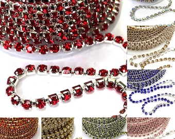 Könnte beinhalten: Sortiment an Strass-Kettenbesatz in verschiedenen Farben, darunter Rot, Gold, Grün, Pink und Blau. Die Kette besteht aus kleinen, quadratischen Strasssteinen, die durch silbernes Metall verbunden sind.