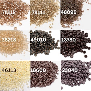 Può includere: Nove colori diversi di perline da seme, ciascuna in un mucchio. I colori sono: marrone chiaro, marrone scuro, nero, bianco, viola chiaro, viola scuro, oro chiaro, oro scuro e trasparente.
