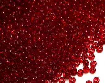 May include: A large quantity of small, round, red glass beads. The beads are translucent and have a slight shine.
