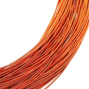 May include: A coiled length of metallic orange wire featuring a tightly wound, ribbed texture along its entire surface. The wire is arranged in a series of parallel, overlapping loops that create a dense, uniform pattern of bright copper-toned lines.
