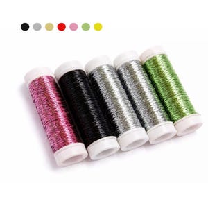 May include: Five spools of metallic thread in a row, each with a white base. Colors include pink, black, silver, and green. The thread is tightly wound, and the spools are angled slightly.