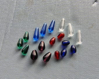 May include: Assortment of glass beads in various colors, including green, blue, red, and clear. The beads are teardrop shaped and have a glossy finish.