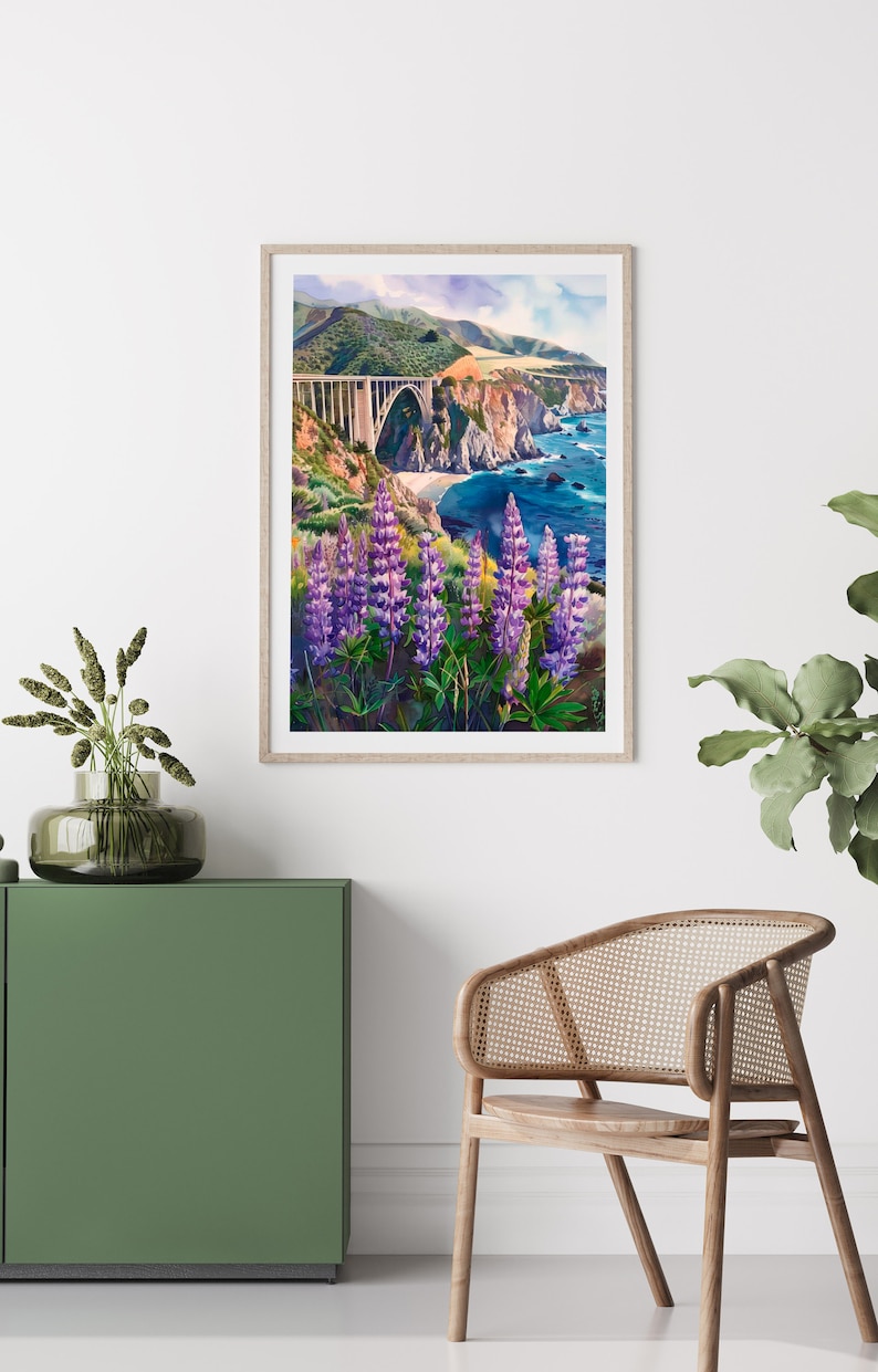 May include: A framed watercolor painting of a bridge over a body of water with a coastline in the background. The bridge is white and the water is blue. There are purple flowers in the foreground.
