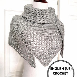 Może przedstawiać: Szal zrobiony na szydełku w kolorze szarym z ażurowym wzorem. Szal jest prezentowany na białym manekinie. W prawym dolnym rogu zdjęcia widoczny jest tekst "ENGLISH (US) CROCHET PATTERN ONLY".