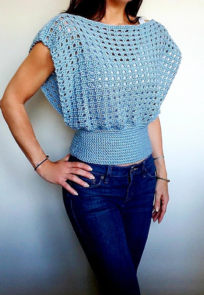 May include: A light blue crochet top with a loose, open-weave design. The top has a fitted waist and short sleeves.