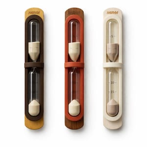 May include: Three HARVIA brand hourglasses with wooden frames in brown, orange, and cream colors. Each hourglass has a clear glass tube with sand inside, marked with 5, 10, and 15-minute increments. The hourglasses are designed for sauna use.