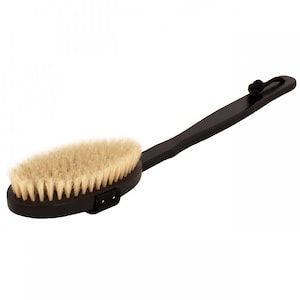 Puede incluir: Un cepillo de baño negro con cerdas naturales y un mango largo de madera. El mango tiene un lazo de cordón negro en el extremo.