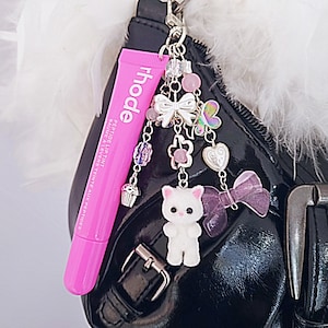 Amuletos de brillo de labios Rhode: Brillo teñido de color rosa pastel con gatito sylvanian