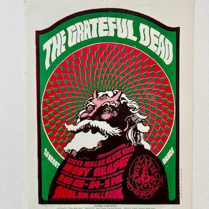May include: A vintage concert poster for The Grateful Dead with Moby Grape and Steve Miller Blues Band. The poster features a red and green psychedelic design with a cartoon devil figure. The concert is scheduled for December 23rd and 24th at the Avalon Ballroom in San Francisco.