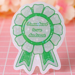 Könnte beinhalten: Grüner und weißer holografischer Aufkleber mit einem Banddesign und dem Text "Remembered to use deodorant".