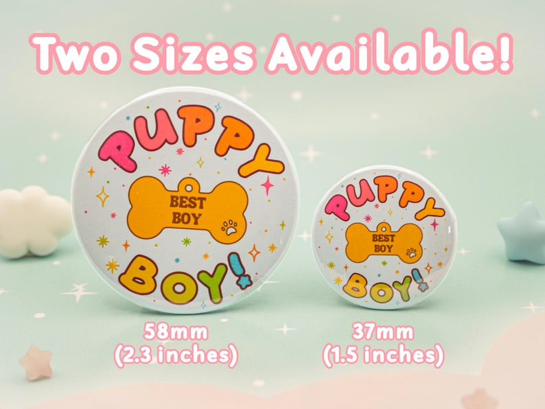 Op de afbeelding: Twee ronde buttons met de tekst "PUPPY BOY!" in roze, oranje en groen. De buttons zijn wit met een bot-afbeelding en steraccenten. De grotere button is 58 mm, de kleinere 37 mm.