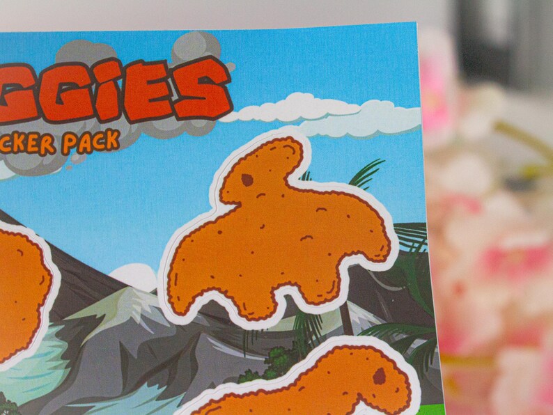 May include: A sticker sheet with a cartoon illustration of a chicken nugget shaped like a dinosaur. The sticker sheet has the text "NUGGIES" and "STICKER PACK" on it.