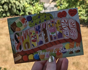 Puede incluir: Una postal colorida con las palabras "In Sweetness There Is Strength" y una ilustración caprichosa de caramelos y personajes. La postal tiene un esquema de color rojo, naranja y amarillo con un borde blanco.