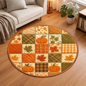 Könnte beinhalten: Ein runder Teppich mit Patchwork-Design aus gesteppten Quadraten. Das Muster zeigt orangefarbene Kürbisse, verschiedene Herbstblätter in Rot-, Orange- und Grüntönen sowie karierte Stoffstrukturen in erdigen Braun- und Goldtönen.