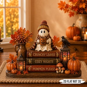 Könnte beinhalten: Eine Tischdekoration mit einer Geisterfigur, die eine Strickmütze und einen Schal trägt und eine Kürbistasse hält. Sie steht auf drei gestapelten Büchern mit den Aufschriften Crunchy Leaves, Cozy Nights und Pumpkin Please, umgeben von Laternen, Kürbissen und Herbstlaub.
