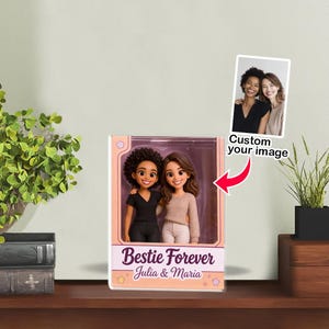 Könnte beinhalten: Ein verpacktes Figurenset mit zwei lächelnden weiblichen Figuren, eine mit dunklem lockigem Haar und einem schwarzen Oberteil, die andere mit braunem welligem Haar und einem beigen Pullover. Auf der Box steht "Bestie Forever" mit den Namen "Julia & Maria". Ein kleines Foto ist mit dem Text "Custom your image" angebracht.