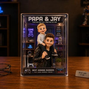 Könnte beinhalten: Eine transparente Acryl-Vitrine mit einem Vater und seinem Sohn, mit dem Text "PAPA & JAY" und "BEST GAMING BUDDIES". Die Vitrine enthält Gaming-Dekoration und die Worte "GAME ON" und "EAT SLEEP GAME REPEAT".