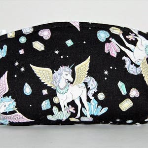 Puede incluir: Bolsa negra con cremallera con un dise&ntilde;o de unicornio y cristal. La bolsa presenta dos unicornios con alas y una variedad de cristales coloridos.