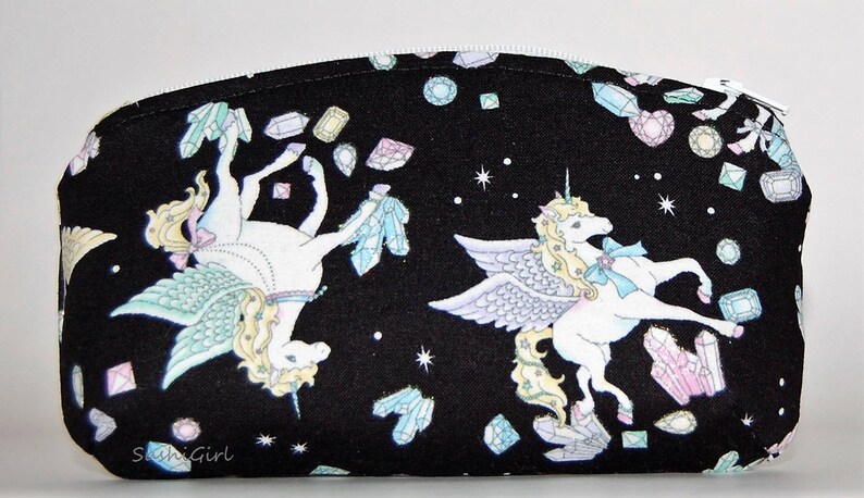 Puede incluir: Bolsa de cosm&eacute;ticos de tela negra con cierre de cremallera. La bolsa presenta un dise&ntilde;o caprichoso de dos unicornios con alas y una dispersi&oacute;n de joyas coloridas.
