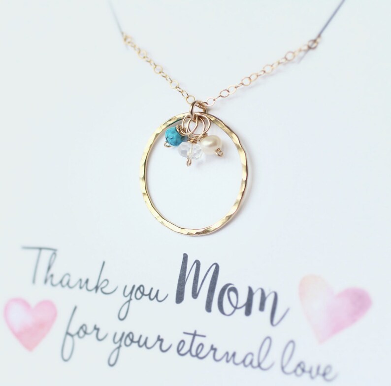 May include: Gold necklace with a hammered circle pendant and turquoise and white beads. The necklace is displayed on a card with the text "Thank you Mom for your eternal love".