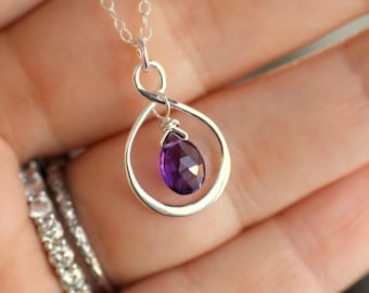 May include: A silver necklace with a delicate infinity symbol pendant featuring a purple amethyst gemstone.