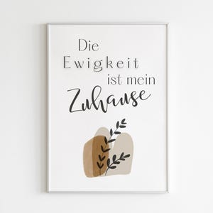 Könnte beinhalten: Ein weißer gerahmter Druck mit dem Text "Die Ewigkeit ist mein Zuhause" in schwarzer Schrift. Der Druck zeigt ein abstraktes Design aus braunen und beigen Formen mit schwarzen Blättern.