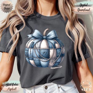 May include: Asphalt-coloured t-shirt featuring a detailed illustration of a patchwork pumpkin with a blue bow and pearl accents. The design includes the text "Original Design" and "Digital Download". The shirt colour is labelled "Asphalt".