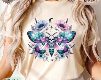 May include: Soft cream-colored t-shirt featuring a colorful moth design with a skull, surrounded by flowers and moons. The moth has teal, purple, and pink wings. The shirt also has the words "Original Design" and "Digital Download".
