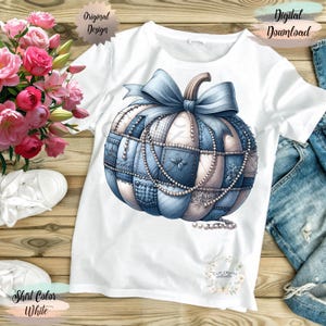 May include: White t-shirt with a blue and white patchwork pumpkin design, a blue bow, and pearl accents. The shirt has the words "Original Design" and "Digital Download" printed on it.